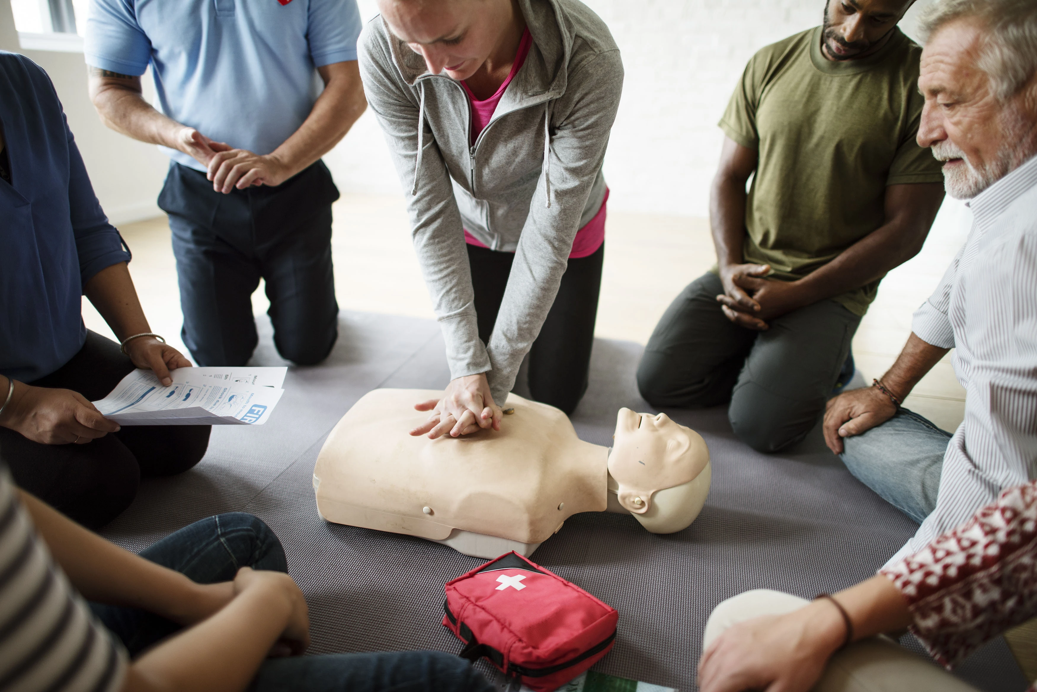 Group of people watching a CPR demonstration in a First Aid training course